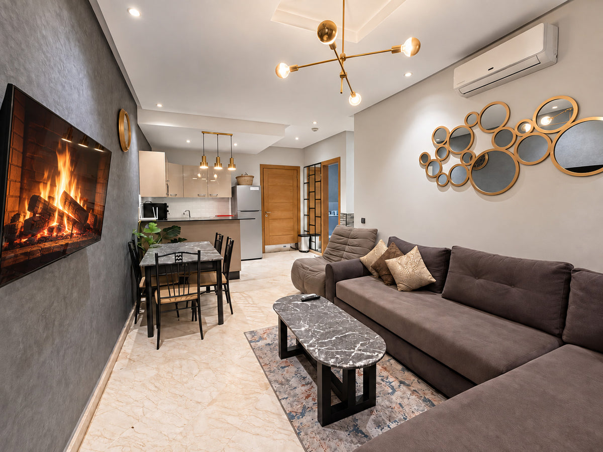 DHAJIA Morocco Hivernage Agadir Bay apartment open-plan living room, kitchen and smart TV fireplace