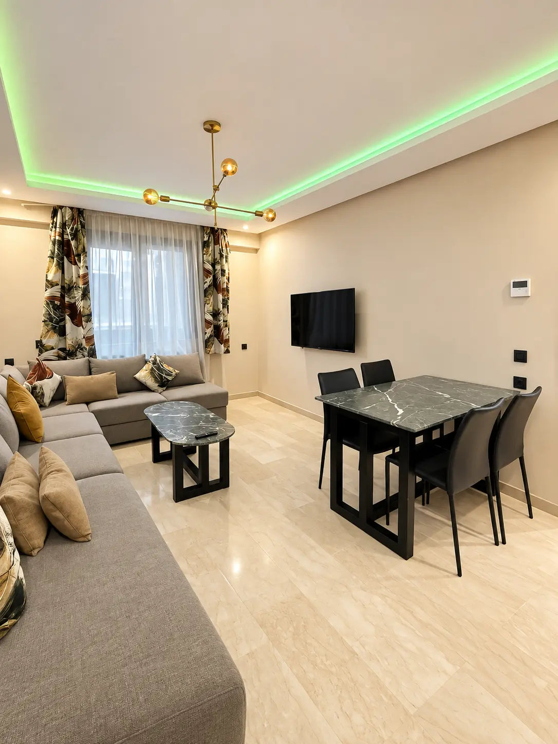 Living room | Bright lounge with corner sofa, dining table and TV in Agadir Bay apartment