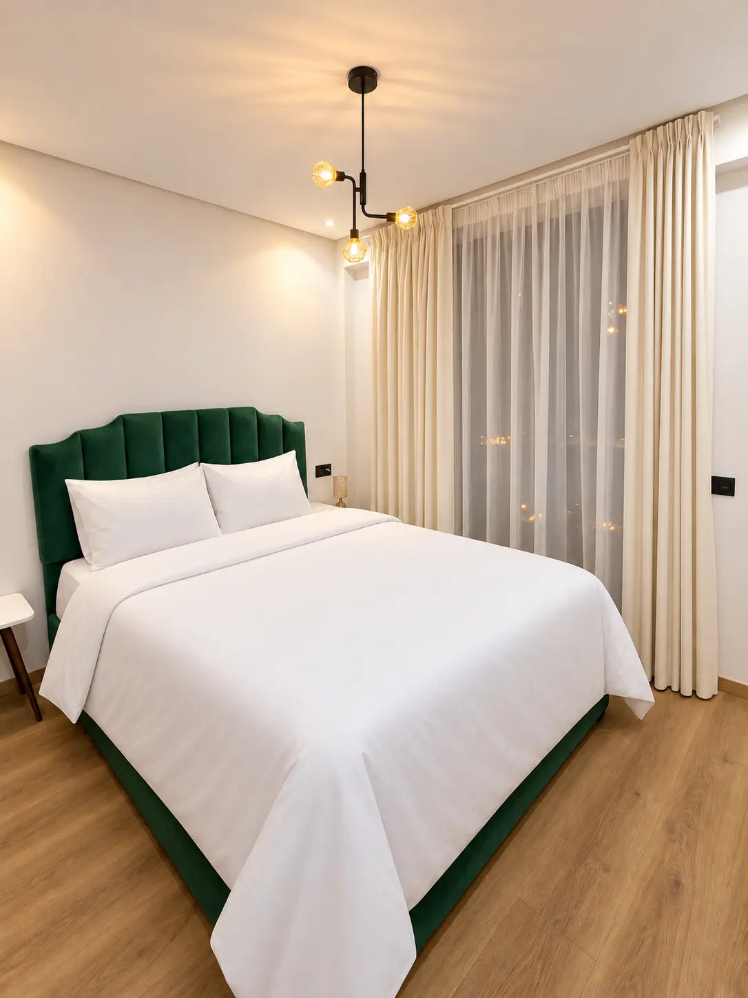 Main bedroom | Double bedroom with green upholstered headboard and guest-ready bedding