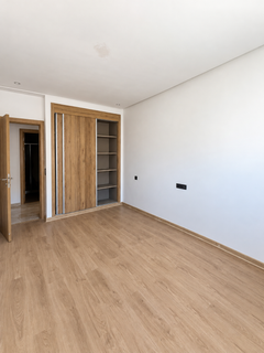 Empty bedroom with wardrobe and open doorway in the Founty apartment