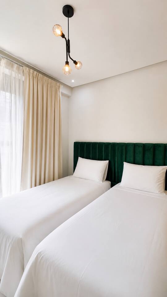 Bedroom detail with green upholstered headboard in the Agadir Bay apartment.