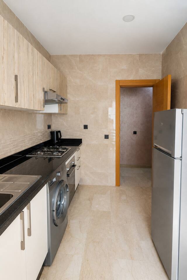 Galley kitchen with fitted cabinets, fridge and washing machine in Agadir Bay.