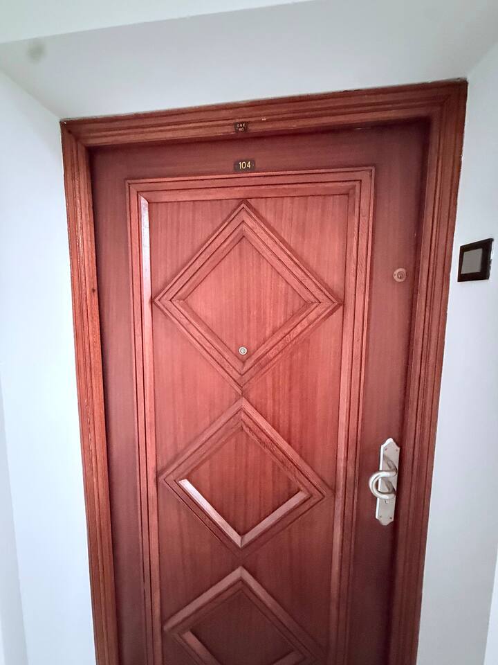 Wooden entrance door to the central Agadir apartment.