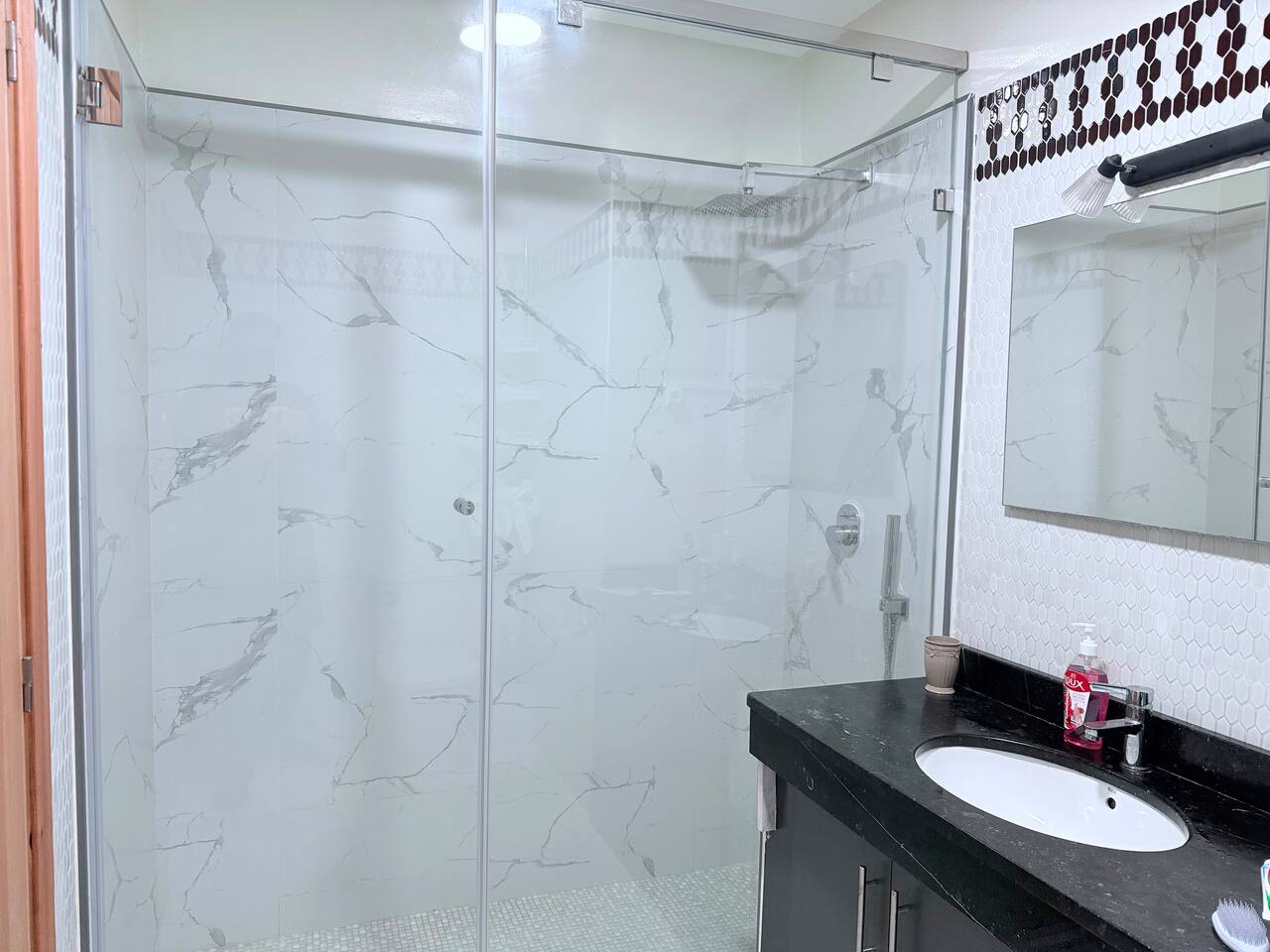 Glass walk-in shower and vanity in the central Agadir apartment bathroom.