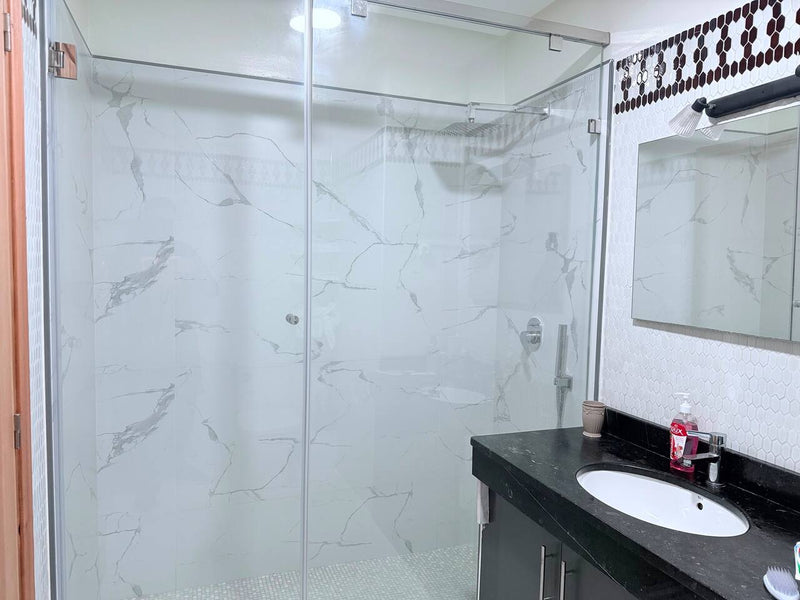 Glass walk-in shower and vanity in the central Agadir apartment bathroom.