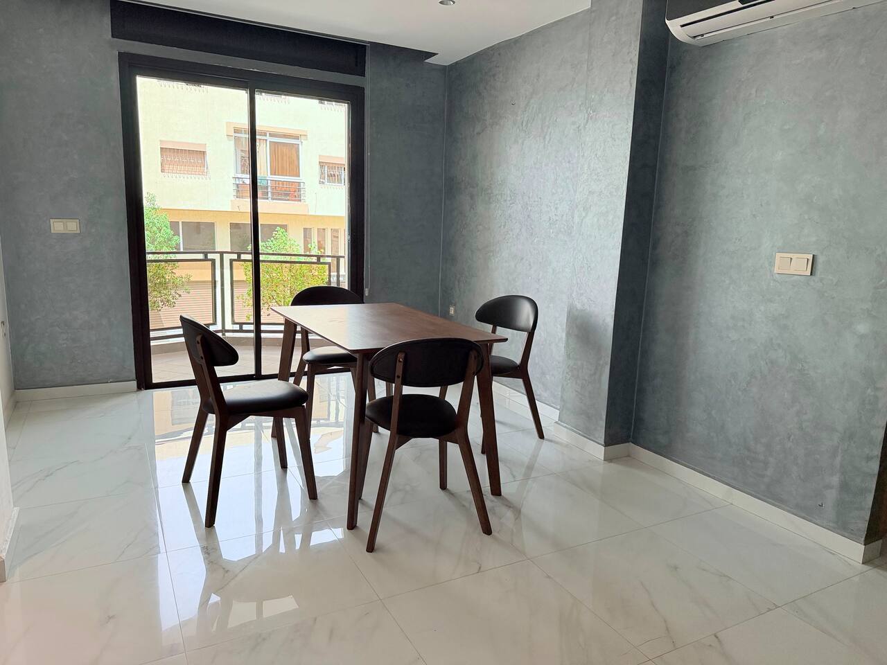 Dining table beside a bright window in the central Agadir apartment.