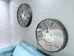 Decorative wall clocks above the blue sofa in the central Agadir living room.
