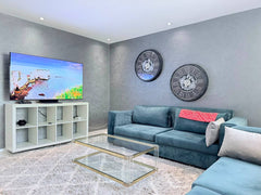 Living room with blue corner sofa and smart TV in the central Agadir apartment.