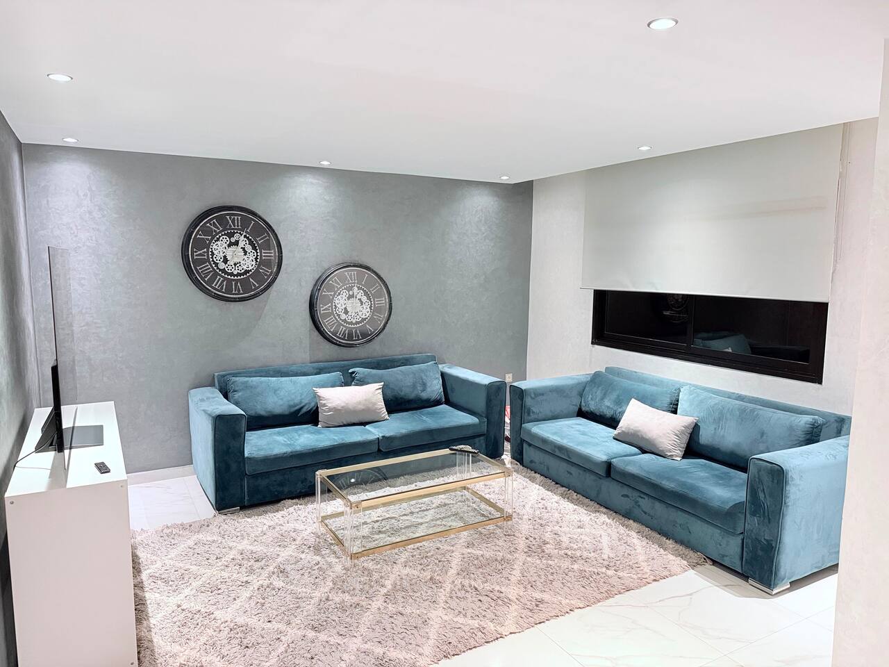 Wide view of the blue corner sofa and smart TV in the central Agadir apartment.
