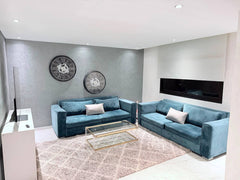 Wide view of the blue corner sofa and smart TV in the central Agadir apartment.