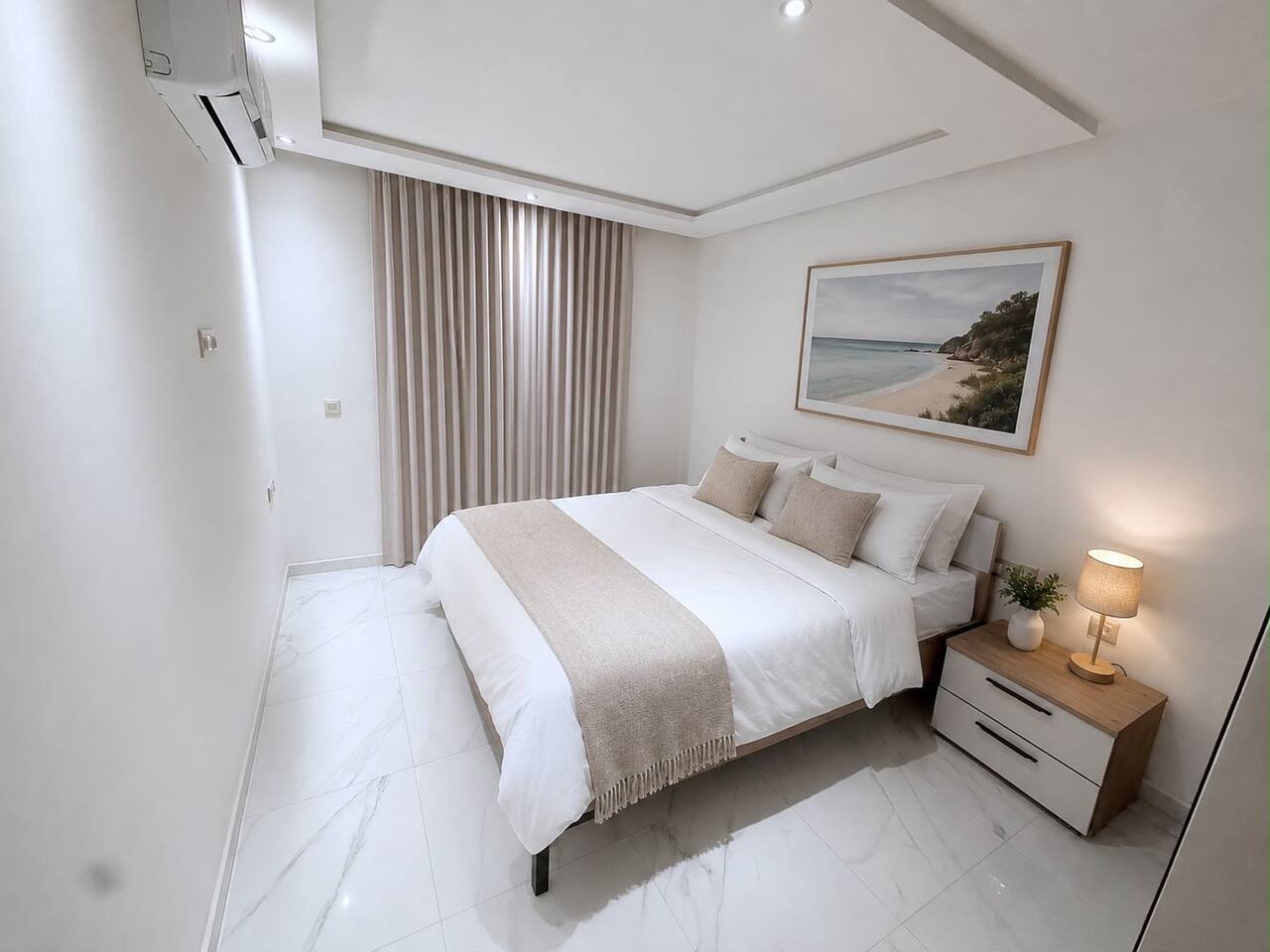 Main bedroom with double bed and wall art in the central Agadir apartment.