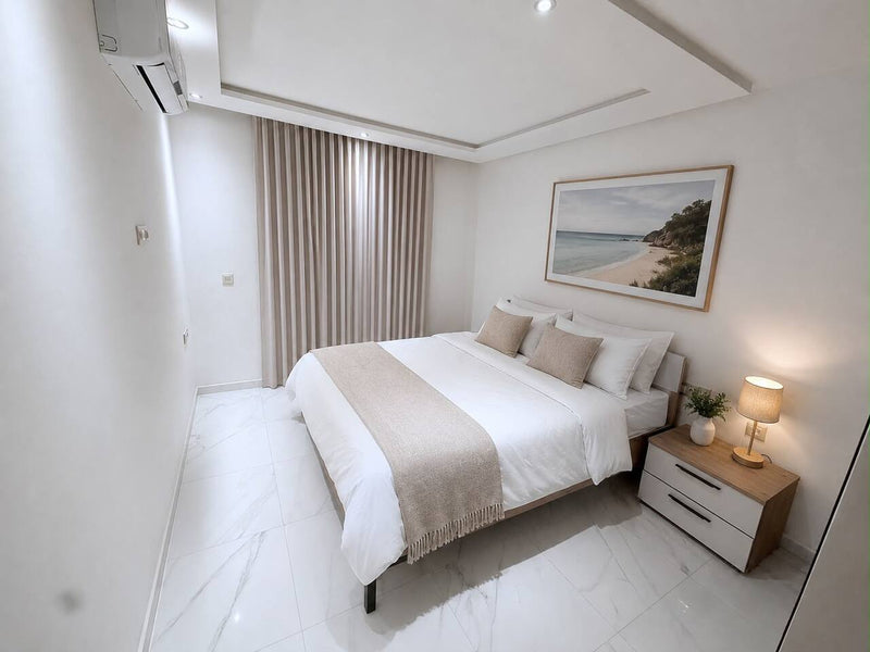Main bedroom with double bed and wall art in the central Agadir apartment.