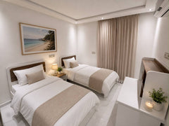 Twin bedroom with two prepared single beds in the central Agadir apartment.