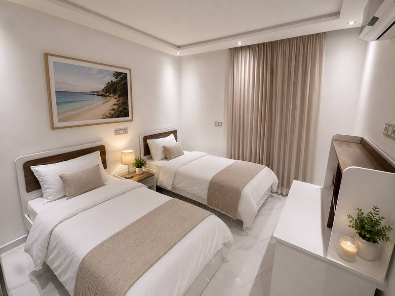 Twin bedroom with two prepared single beds in the central Agadir apartment.