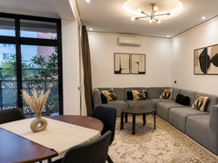 Modern living and dining space in DHAJIA Haut Founty, Agadir apartment with balcony light, AC, warm interiors and comfortable seating.