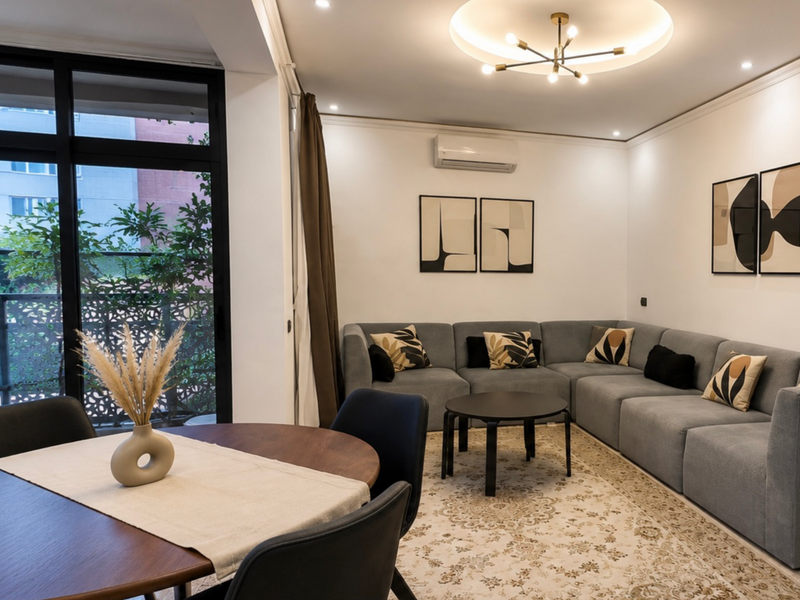 Modern living and dining space in DHAJIA Haut Founty, Agadir apartment with balcony light, AC, warm interiors and comfortable seating.