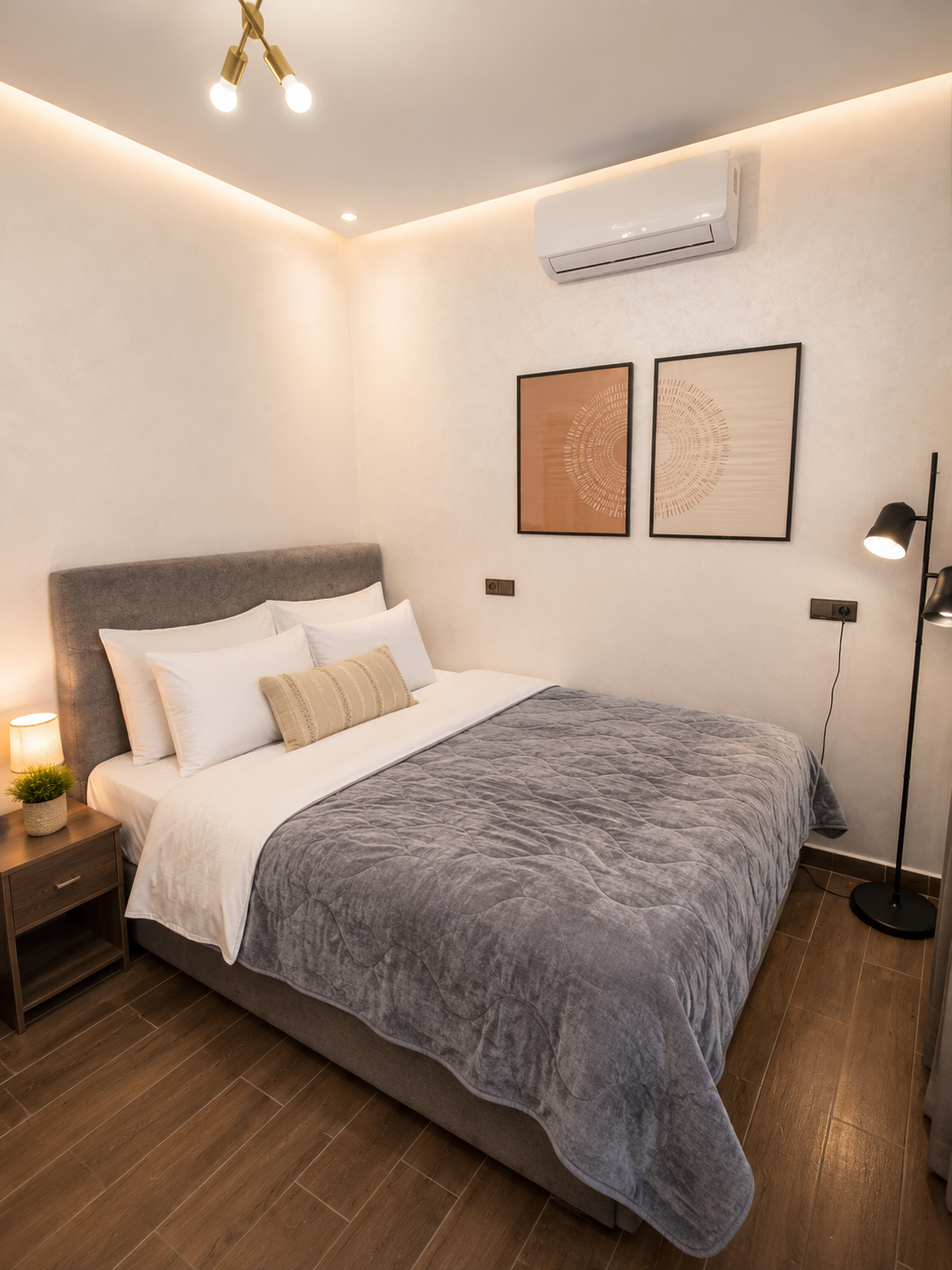 Comfortable main bedroom in DHAJIA Haut Founty, Agadir apartment with soft bedding, AC, warm lighting and modern décor.