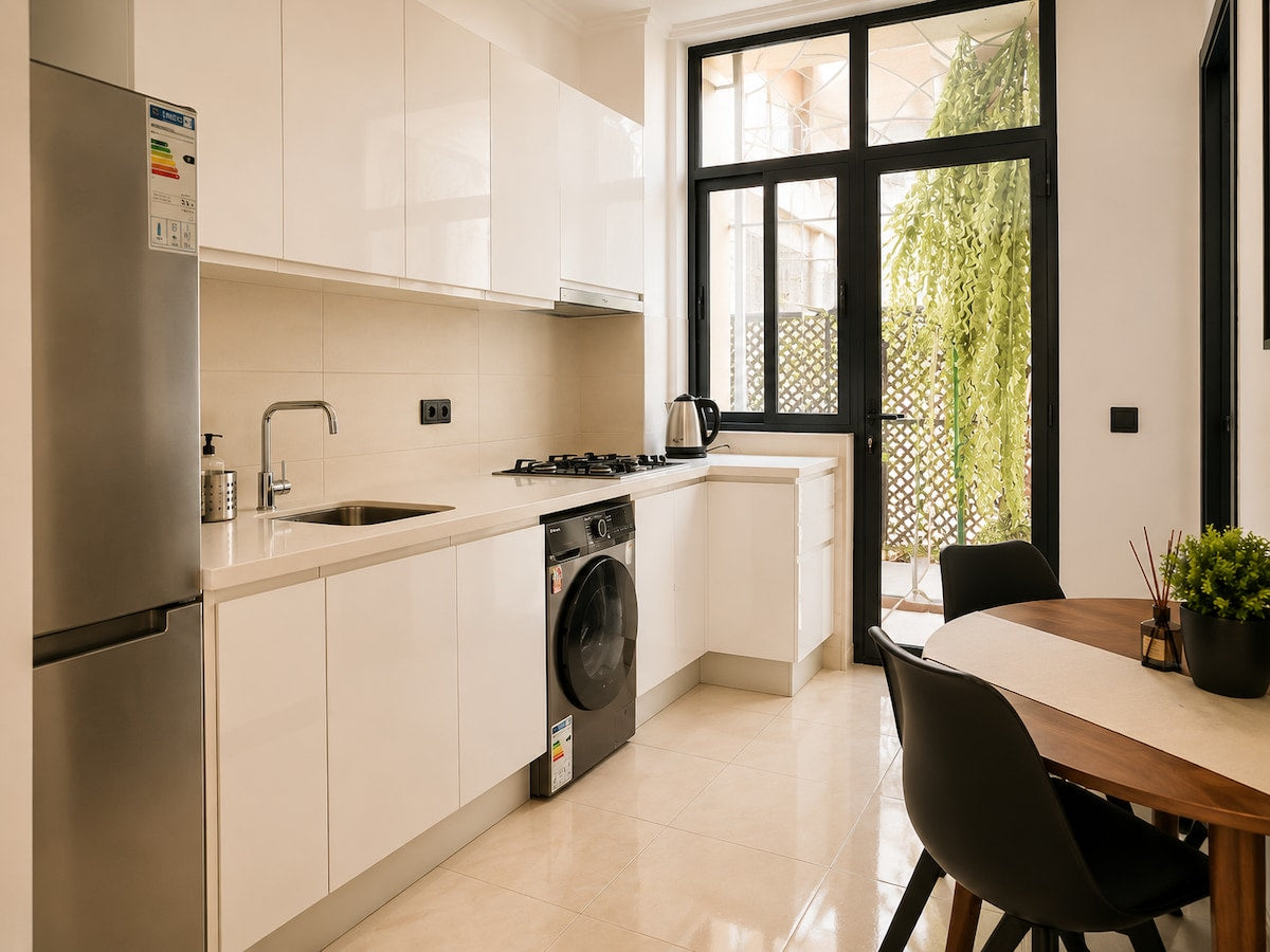 Modern white kitchen with gas hob, refrigerator and washing machine in Haut Founty, Agadir.