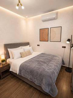 Main bedroom with large bed, air conditioning and warm lighting in Haut Founty, Agadir.