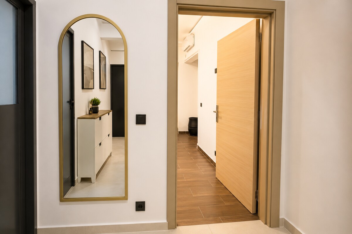 Bright apartment entrance with full-length mirror and warm lighting in Haut Founty.