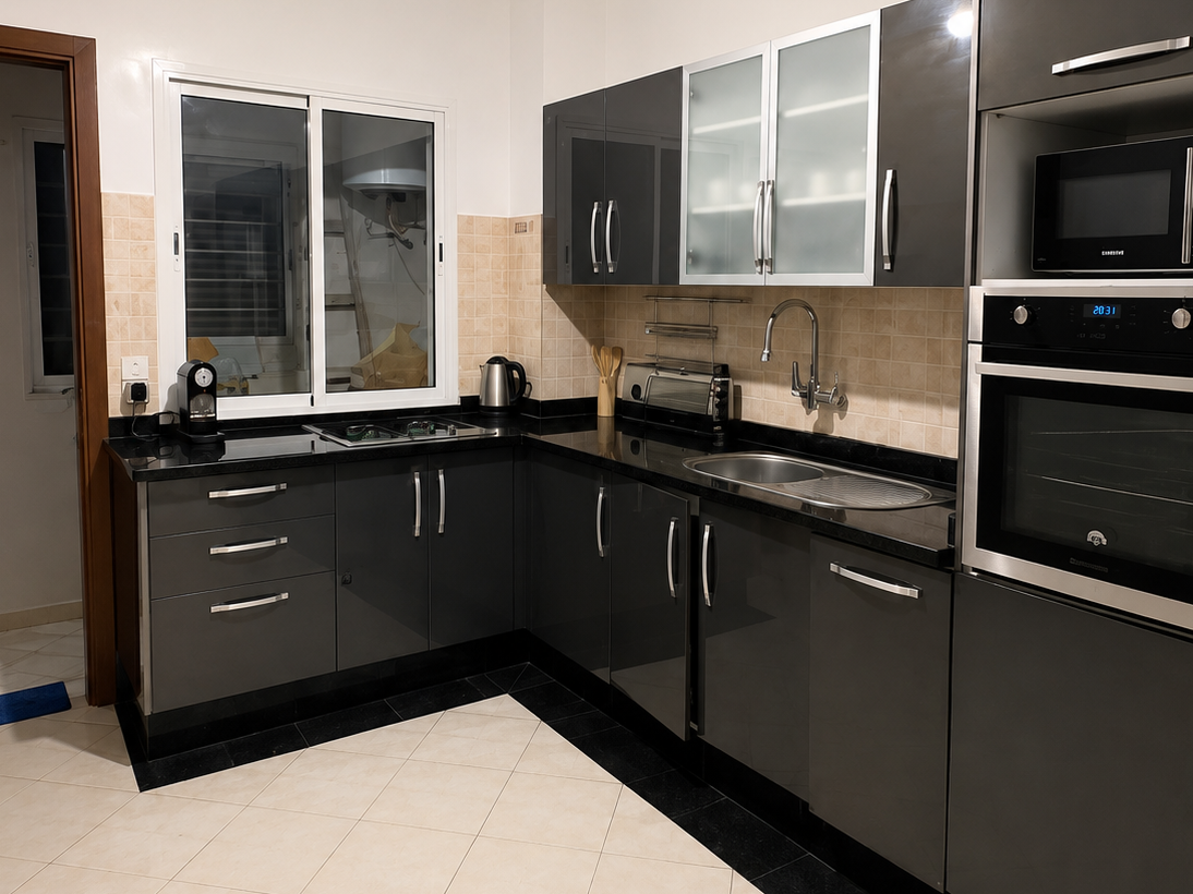 Equipped black kitchen with oven and fitted cabinets in the Haut Founty apartment.