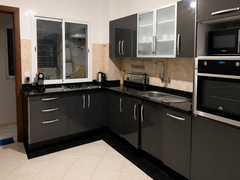 Equipped black kitchen with oven and fitted cabinets in the Haut Founty apartment.