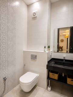 Second bathroom with wall-mounted toilet and vanity in the Haut Founty apartment.