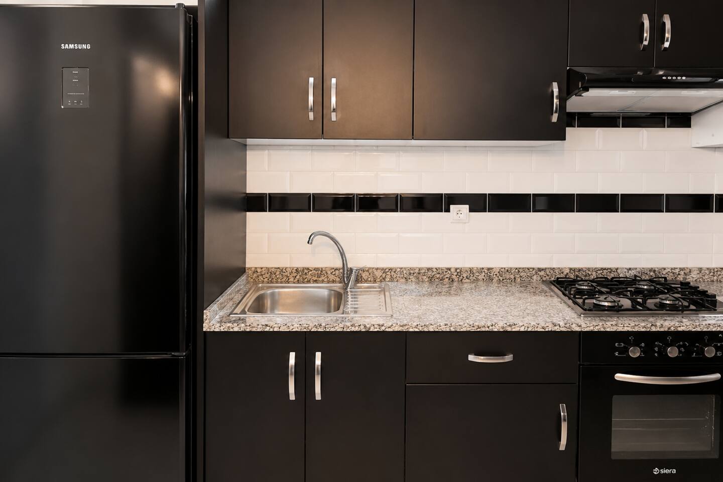 Kitchen sink, gas hob and black fitted cabinets in Hay Mohammadi.