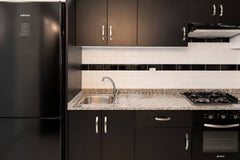 Kitchen sink, gas hob and black fitted cabinets in Hay Mohammadi.