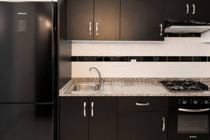 Kitchen sink, gas hob and black fitted cabinets in Hay Mohammadi.