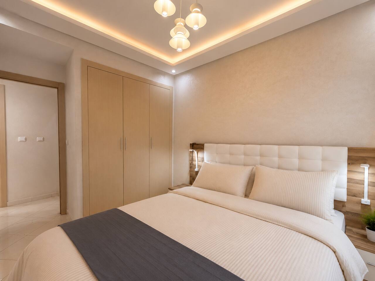 Main bedroom with fitted wardrobes and upholstered double bed in Hay Mohammadi.