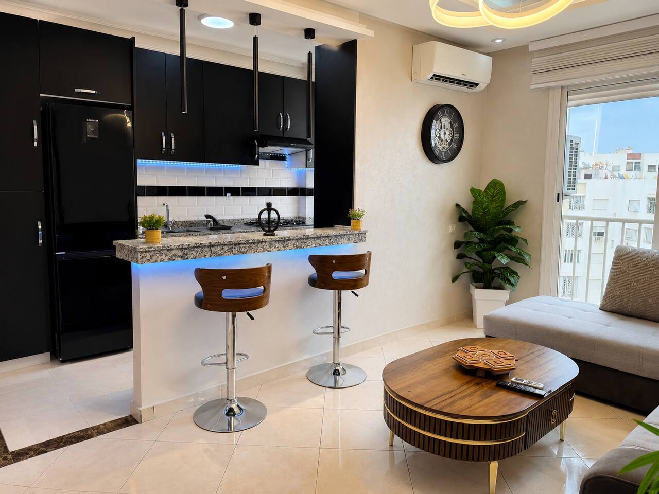Open kitchen and living area with corner sofa in the Hay Mohammadi apartment.