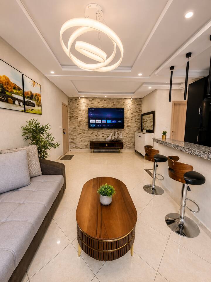 Open-plan living room with corner sofa and kitchen breakfast bar in Hay Mohammadi.