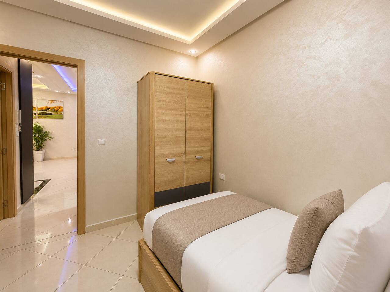 Twin bedroom with wardrobe and two prepared single beds in Hay Mohammadi.