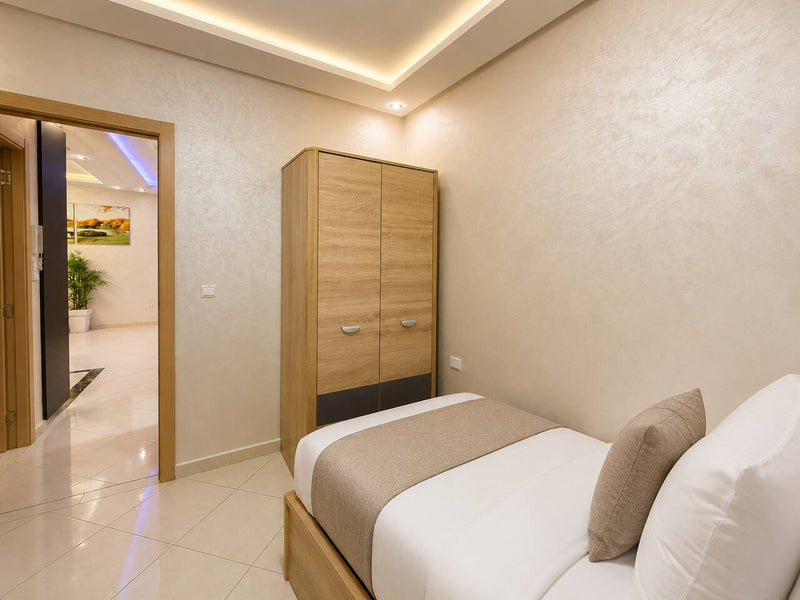 Twin bedroom with wardrobe and two prepared single beds in Hay Mohammadi.