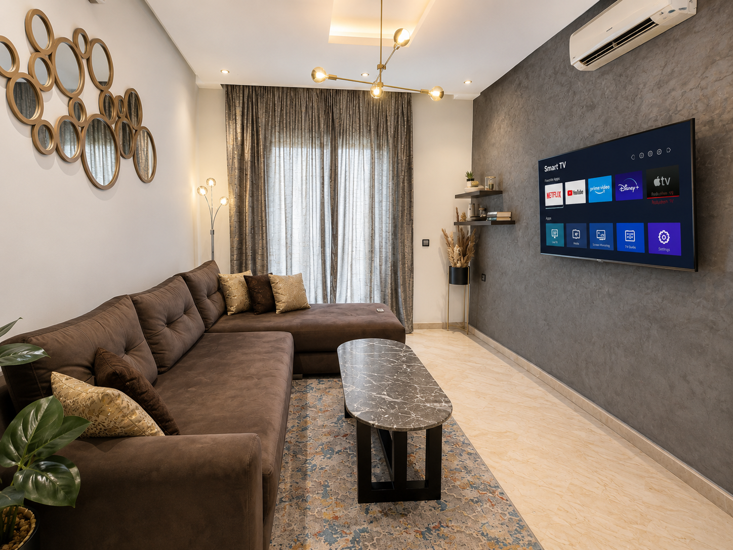 Living room with sofa and wall-mounted smart TV in the Hivernage apartment.