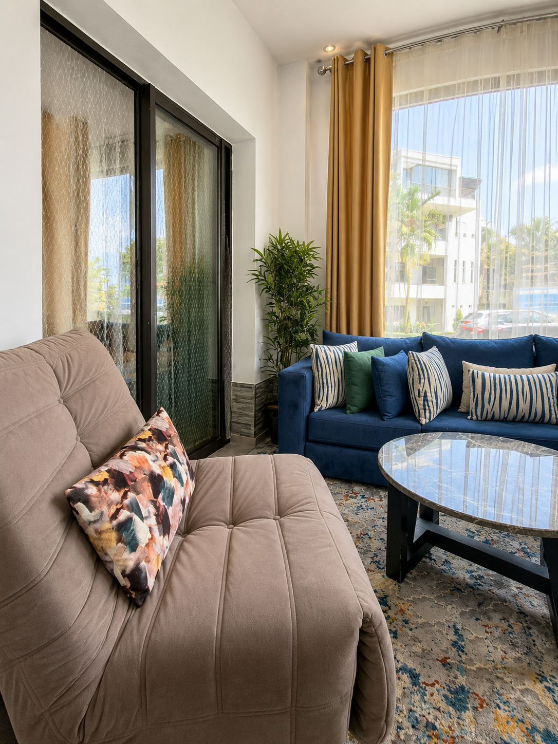 Comfortable living room seating beside large windows in the Hivernage apartment.