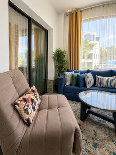 Comfortable living room seating beside large windows in the Hivernage apartment.