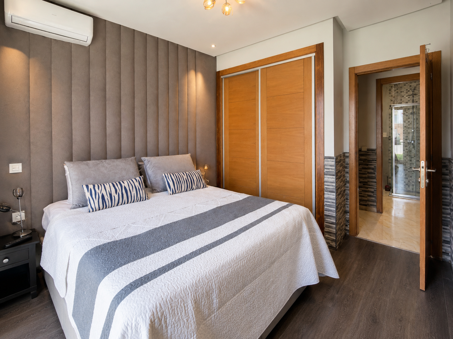 Main bedroom with double bed and en-suite bathroom entrance at Hivernage Agadir Bay.