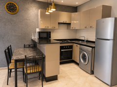 Open-plan kitchen and dining area with washing machine in the Hivernage apartment.
