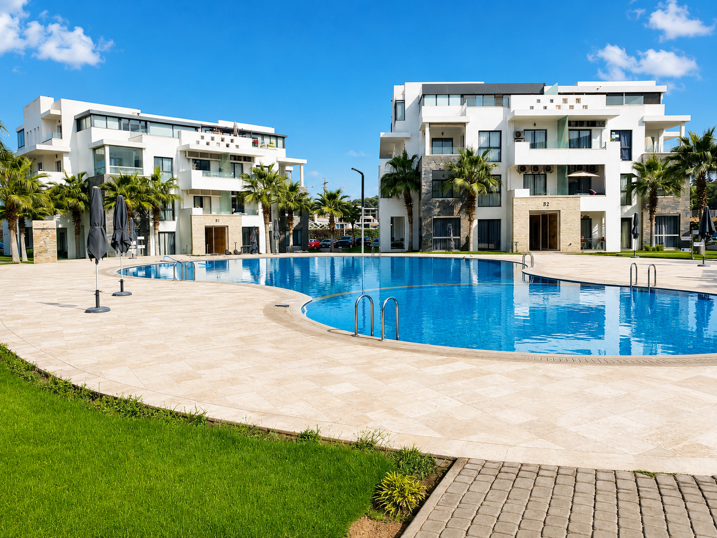 Hivernage Agadir Bay swimming pool beside a landscaped lawn and apartment buildings.