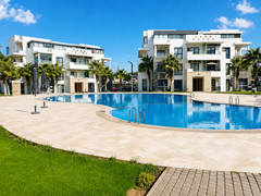 Hivernage Agadir Bay swimming pool beside a landscaped lawn and apartment buildings.