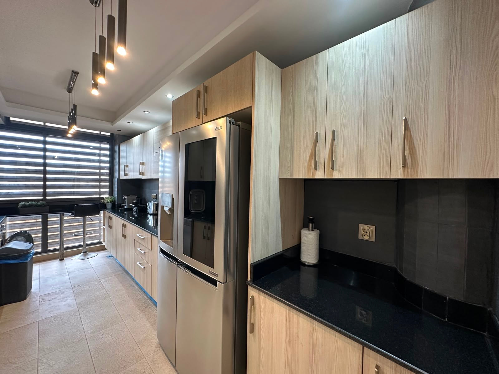 Equipped kitchen with fridge freezer and breakfast seating at the Iken Gardens apartment.