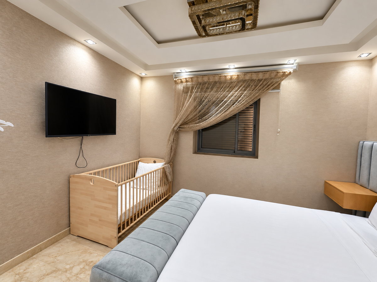 Bedroom with television and dresser at the Iken Gardens holiday apartment, Agadir Bay