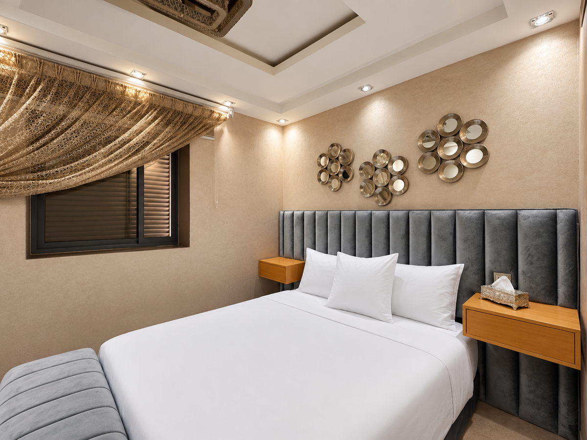 Bedroom with upholstered headboard at the Iken Gardens holiday apartment, Agadir Bay