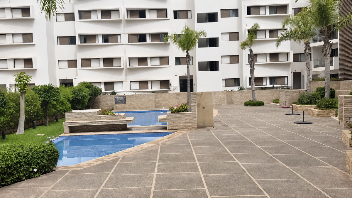 Shared swimming pool and paved courtyard at the Iken Gardens residence.