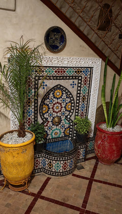 Traditional tiled fountain and stairwell in the Marrakech riad