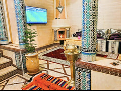 Moroccan lounge with tiled columns and fireplace in the Marrakech riad