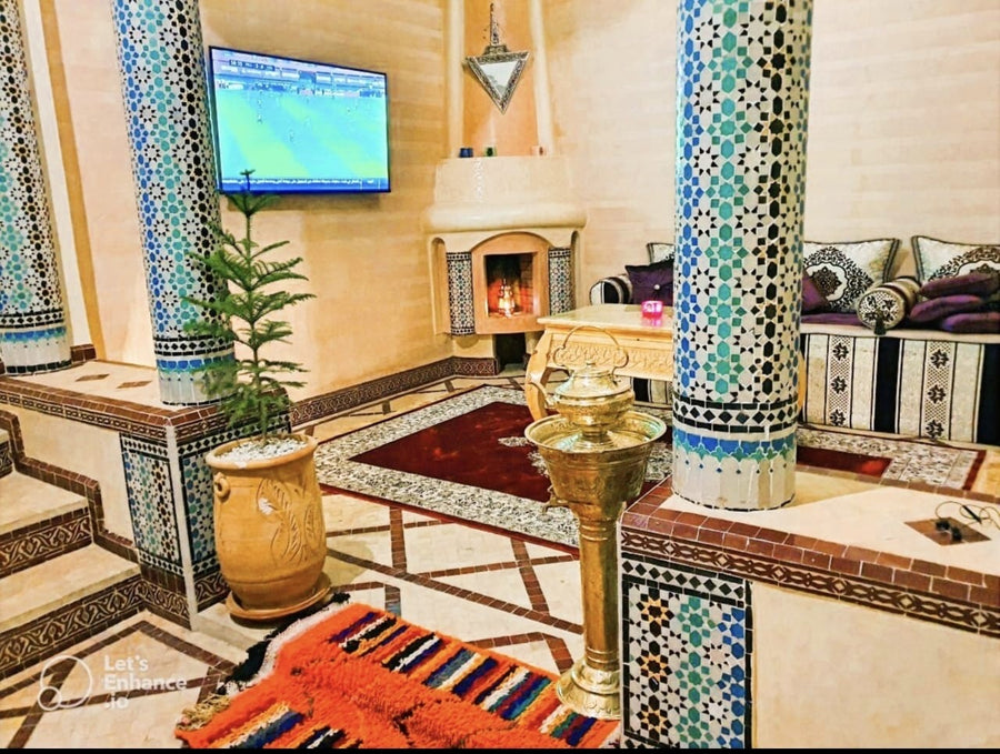 Moroccan lounge with tiled columns and fireplace in the Marrakech riad