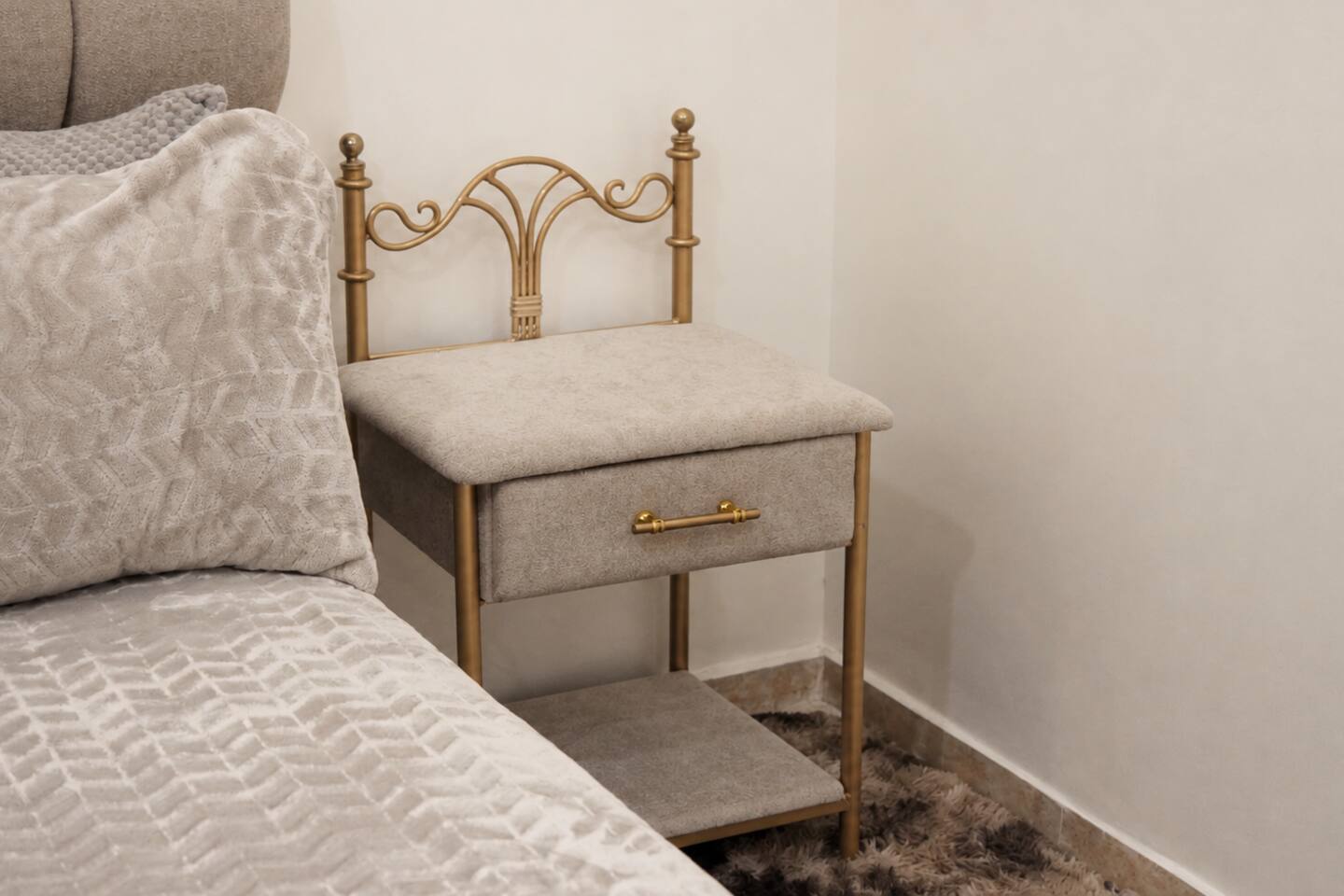 Bedside table and upholstered bed detail in the premium apartment near Agadir Bay.